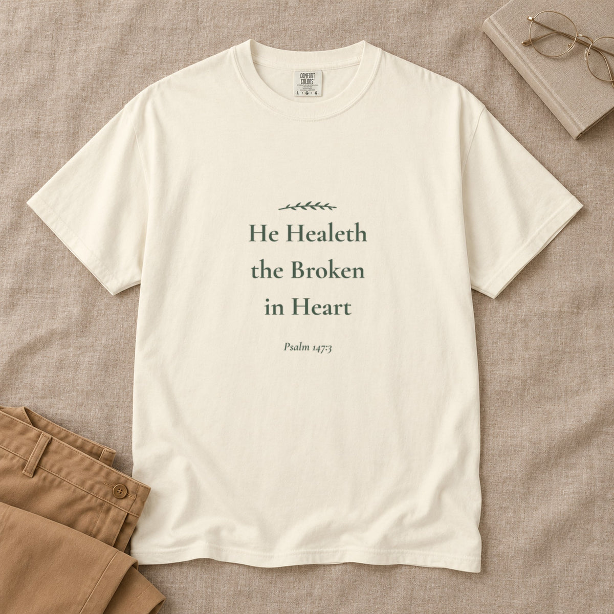 He Healeth the Broken in Heart Scripture tee in Ivory — styled flat lay