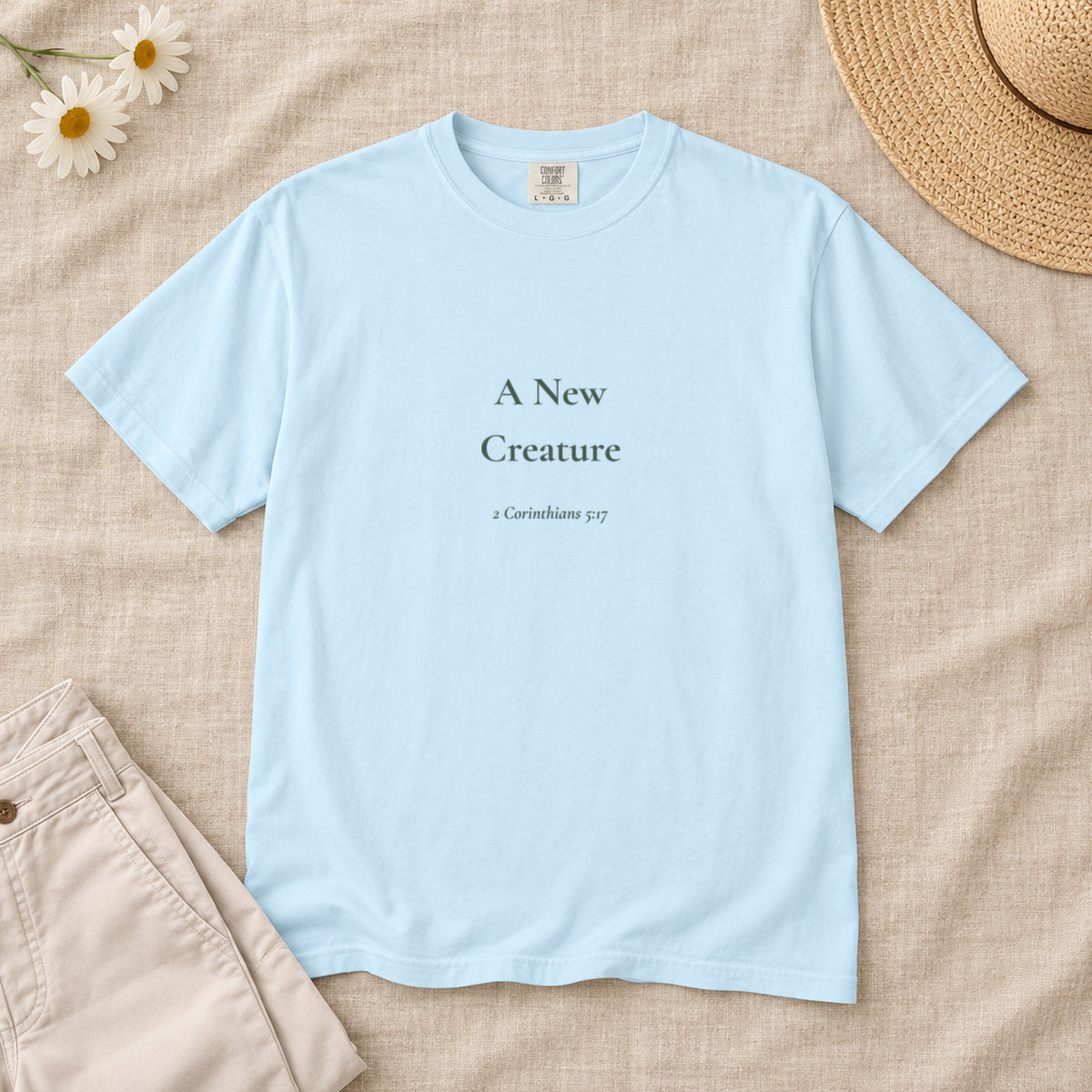 A New Creature Scripture tee in Chambray — styled flat lay