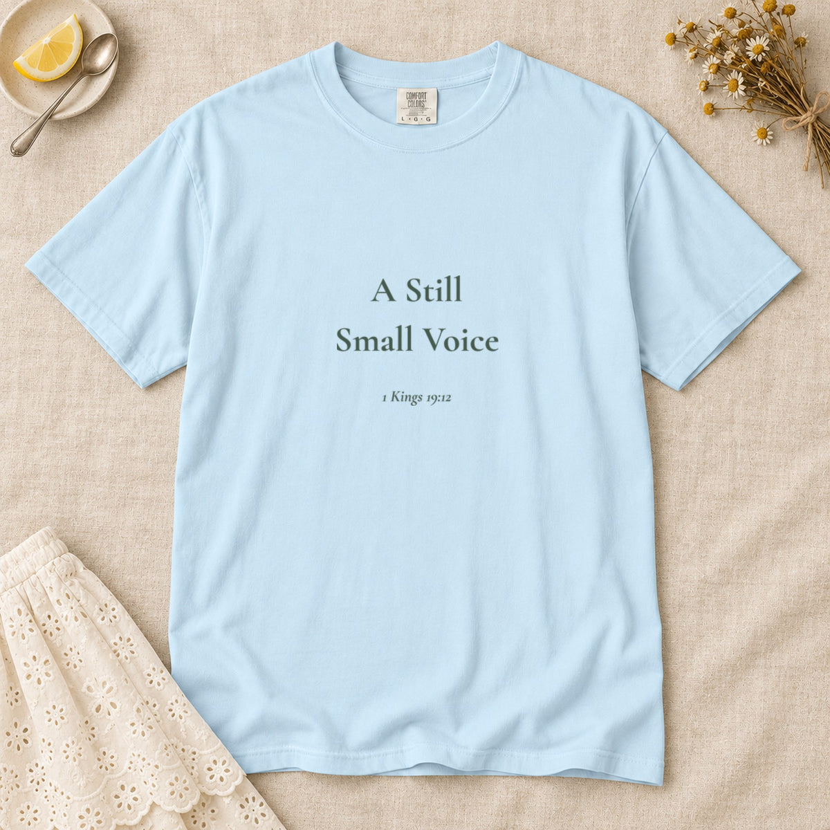 A Still Small Voice Scripture tee in Chambray — flat lay